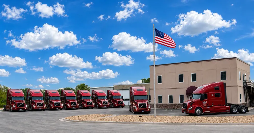 Proudly American trucking company parks new Volvo trucks for Company Drivers around a flagpole at Southland Transportation